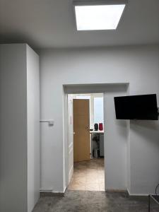 a white room with a television and a hallway at Twin-Tam House in Timişoara
