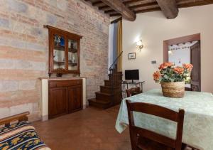 Una habitación con una mesa con un jarrón de flores encima. en La Pieve di San Martino, en Colle Val D'Elsa