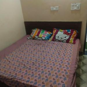 a bed with two pillows on top of it at Gaurangi seva sadan in Mathura +2 photos