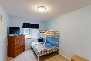 a small bedroom with a bunk bed and a television at Hip Nautic in Rockaway Beach