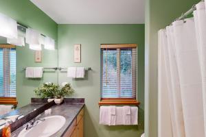 a green bathroom with a sink and a mirror at Hip Nautic in Rockaway Beach