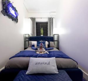 a bedroom with a bed with a blue comforter at Swanky Seaside Sanctuary W Foozeball - Southend in Southend-on-Sea