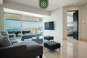 ein Wohnzimmer mit Sofa und Fernseher in der Unterkunft Oceanview 3 BR Penthouse with Private Terrace - BBQ in Puerto Vallarta