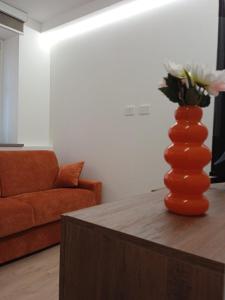 an orange vase sitting on a table in a living room at Casa Bùgia Nen in Alba