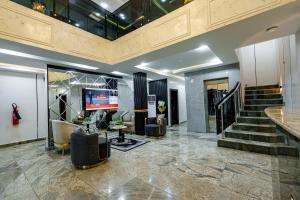 哈科特港Roston Hotels的大堂配有电视,楼梯配有椅子