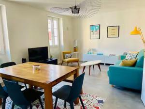 a living room with a table and a blue couch at Appartement lumineux Côte des Basques in Biarritz