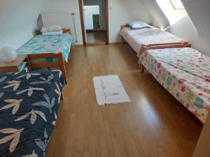 a room with three beds and a wooden floor at Nivekerke 8 Nieuwmunster De Haan, 3-bedroom holiday house for 4 to 6 people, between Wenduine, 1 km, and De Haan, 2 km, 500 meters from the beach,15 min from Bruges, Ostend and Knokke, nice big fenced garden in Zuienkerke