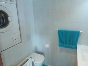 a bathroom with a toilet and a blue towel at Nivekerke 8 Nieuwmunster De Haan, 3-bedroom holiday house for 4 to 6 people, between Wenduine, 1 km, and De Haan, 2 km, 500 meters from the beach,15 min from Bruges, Ostend and Knokke, nice big fenced garden in Zuienkerke +18 photos