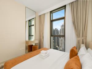 a bedroom with a bed and a large window at Modern 1BR in DOWNTOWN I Near DUBAI MALL & FOUNTAIN in Dubai