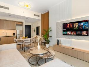 a living room with a tv on the wall at Modern 1BR in DOWNTOWN I Near DUBAI MALL & FOUNTAIN in Dubai