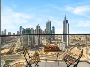 a balcony with a table and chairs and a city skyline at Modern 1BR in DOWNTOWN I Near DUBAI MALL & FOUNTAIN in Dubai