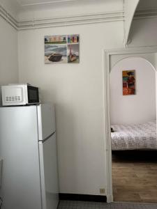 a kitchen with a refrigerator and a microwave at Chez Bleu in Villejuif