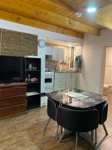 a kitchen with a table with chairs and a television at MAKAVIZA in Villa Pehuenia