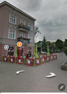 a building with a clock on the ground in front of it at Centrum 2pokoje 4łożka przy MACDonald ulica Witosa 1 in Piła