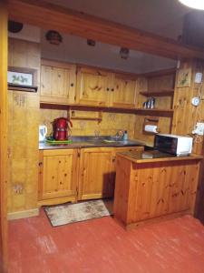 una cucina con mobili in legno e un lavello di La cuccia di Elfo a Prali
