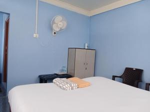 a bedroom with a white bed and a blue wall at N D Phisha Homestay in Cherrapunji