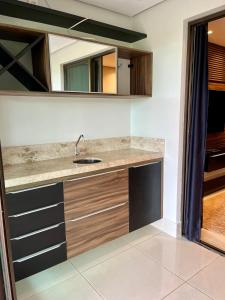 a kitchen with a sink and a mirror at Flat no Condomínio Alto da Serra Villas in Bananeiras