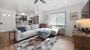 a living room with a white couch and a kitchen at Arrowleaf Family House with Hot Tub in Kanab