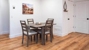 a dining room table with chairs and a painting on the wall at Arrowleaf Family House with Hot Tub in Kanab