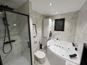 a white bathroom with a shower and a toilet at Le COSY in Pontault-Combault