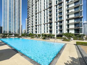 a large swimming pool in front of tall buildings at Modern 1BR in DOWNTOWN I Near DUBAI MALL & FOUNTAIN in Dubai +36 photos