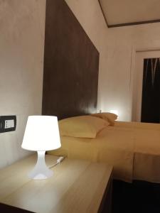 a bedroom with a bed and a table with a lamp at appartement de Maison Manu in Perosa Argentina
