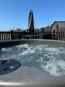 a hot tub with water in it on a patio at Ffrith Park hotel pods in Prestatyn