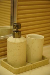 a soap dispenser and a cup on a shelf at Royal Elegance Apartment in Bucharest +27 photos