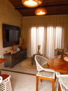 a living room with a television and a table and chairs at Casa Namolmar in Acaraú