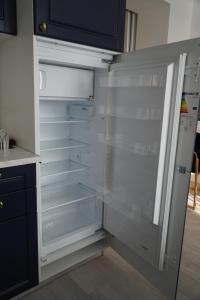 an empty refrigerator with its door open in a kitchen at Royal Elegance Apartment in Bucharest