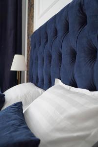 a close up of a bed with a blue headboard at Royal Elegance Apartment in Bucharest