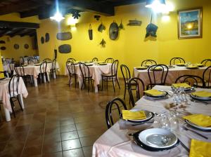 a dining room with tables and chairs and yellow walls at Agriturismo Lu Colbu in Trinità d'Agultu e Vignola