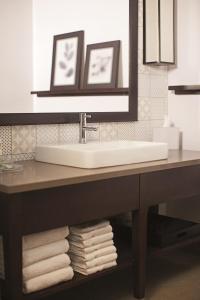 a bathroom with a sink and a pile of towels at Country Inn & Suites by Radisson Asheville River Arts District in Asheville