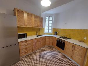a kitchen with wooden cabinets and a refrigerator at Dar Collon in Tangier