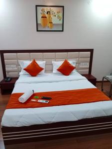una camera da letto con un letto grande con cuscini arancioni di Hotel Raviraj Palace a Rajkot