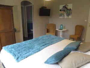 Un dormitorio con una cama con una manta azul. en Manoir du Brugnobois, en Surques