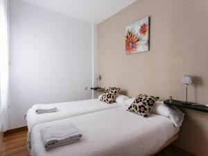 two beds in a room with white walls at Apartamentos Señorio de Haro 3000 in Haro