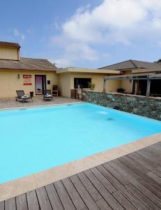 a large blue swimming pool in front of a house at Appartement confort et équipé proche de la plage in Sisco