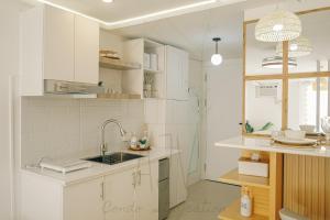 a kitchen with white cabinets and a sink at AJV Condo Staycation in Manila +19 photos