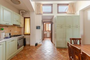Una cocina con gabinetes blancos y una mesa de madera. en Sunflower near the center with Private Parking, en Perugia