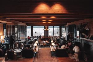 a restaurant with people sitting in chairs and tables at Hotel Catedral Patagonia Ski & Wellness in San Carlos de Bariloche