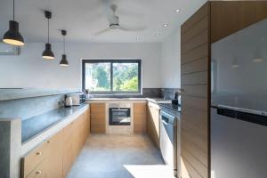 a kitchen with white walls and a large window at Bai Saho Villa 4br - Private Pool & Walk To Beach in Mae Nam