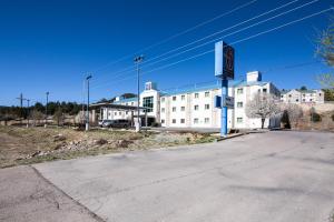 una calle vacía frente a un gran edificio blanco en Motel 6-Ruidoso, NM, en Ruidoso