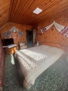 a bedroom with a large bed in a wooden room at Casa Santa Maria Bran in Moieciu de Jos