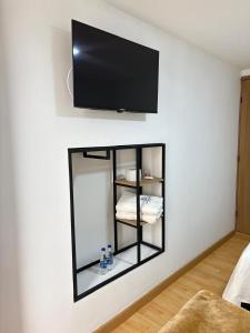 a mirror on a wall with a tv on a wall at Dadison Plaza Hotel in Piedecuesta