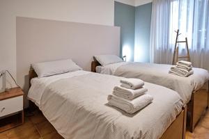 two beds with towels on top of them in a room at La Casa dei Nonni in Ferno