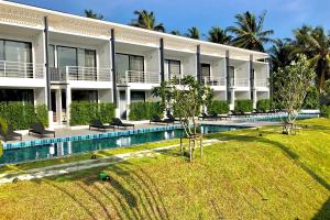 a resort with a swimming pool in front of a building at The Blue Lotus in Mae Nam