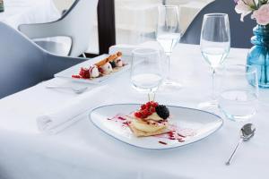 a plate of food on a table with wine glasses at JR Hotels Bari Grande Albergo delle Nazioni in Bari