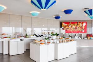 a large kitchen with white counters with food at JR Hotels Bari Grande Albergo delle Nazioni in Bari