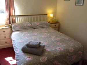 a bedroom with a bed with a bedspread with flowers on it at Black Swan Guest House in Gainsborough